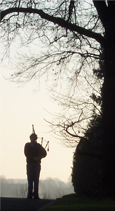 A lone piper plays his tribute at the Margraten cemetery